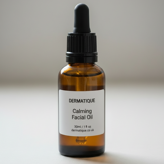 Bottle of Dermatique Calming Facial Oil on pebbles with a blurred natural background